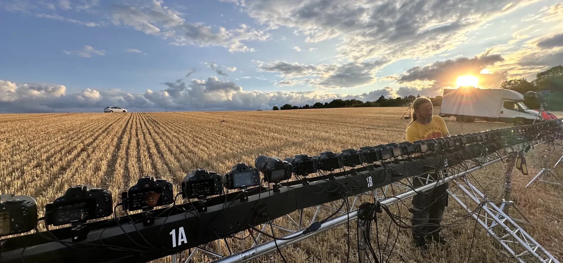 Sunset over the field, with the line of stills cameras in the foreground